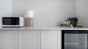A kitchen with a microwave, a lamp, a coffee maker, and a dishwasher. - 44 Adelaide Street (Surry Hills)