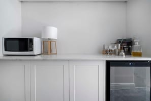 Eine Küche mit Mikrowelle, Lampe, Kaffeemaschine und Geschirrspüler.