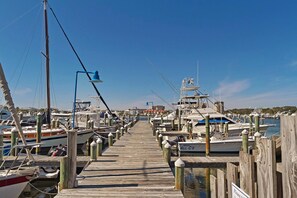 A wooden pier leading to a marina with boats docked on both sides. - Sandpiper Cove 8242 (Destin)