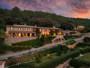 A multi-story building with a stone facade, a central courtyard, and a staircase leading to an upper level. - The Dream Valley of Mallorca (Pollença)