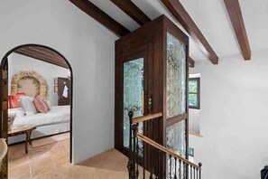 A staircase with a wooden handrail and a glass door with intricate patterns. - The Dream Valley of Mallorca (Pollença)