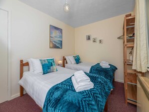 A bedroom with two beds, a wooden ladder, a painting, and a small shelf with items. - Anglesey Country Retreat (Amlwch)