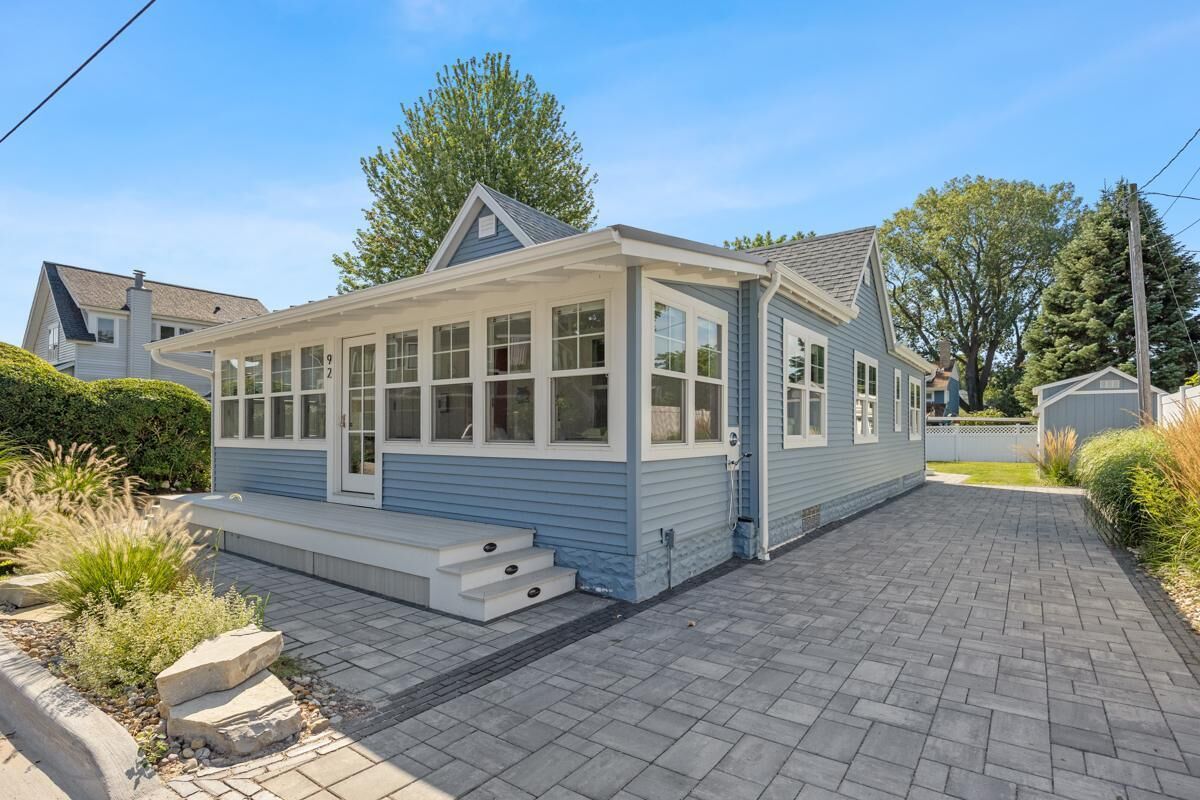 A single-story house with a covered porch, a small front yard, and a paved driveway.