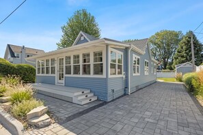 A single-story house with a covered porch, a small front yard, and a paved driveway.
