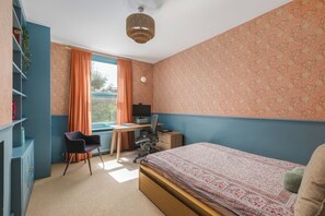 A room with a bed, desk, chair, and a bookshelf. - Charming 2BDR Garden Home in Turnpike Lane (Greater London)