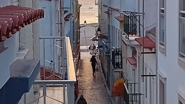 Une rue étroite, bordée de bâtiments des deux côtés, qui mène à la mer.
