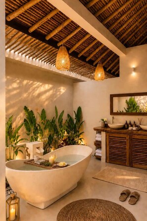 A bathroom with a freestanding bathtub, a wooden vanity, and a mirror above the sink. - Villa Juma (Kabupaten Badung)