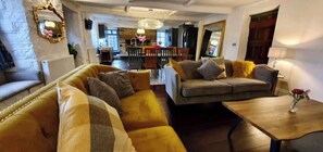 A living room with a sofa, a coffee table, and a dining area in the background.