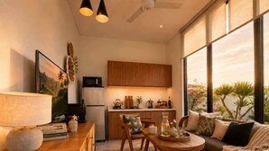 A modern kitchen with wooden cabinets, a dining area with a round table, and a sofa with cushions. - Villa Hibiscus I (Kabupaten Badung)