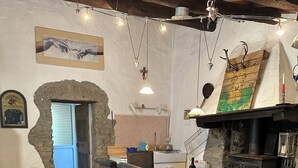 Un comedor rústico con una mesa de madera, sillas y una pared de piedra.