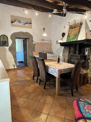 Ein rustikaler Essbereich mit Holztisch, Stühlen und einer Steinwand.