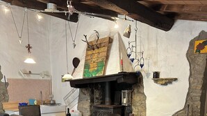Comedor rústico con pared de piedra, mesa de madera y sillas.