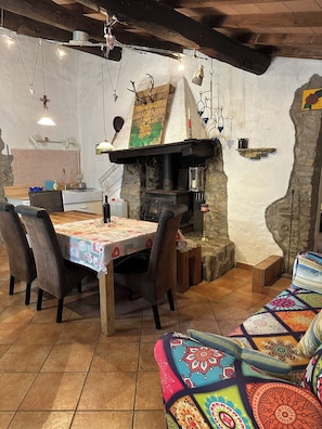 Ein rustikaler Essbereich mit einer Steinwand, einem Holztisch und Stühlen.