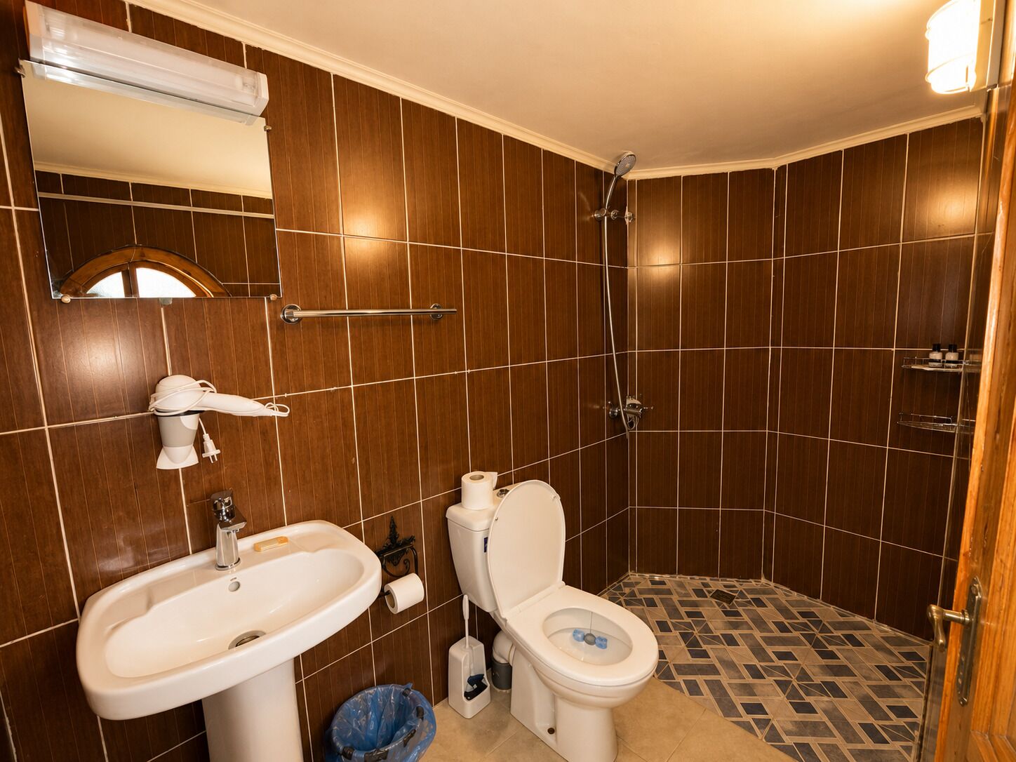 A bathroom with a toilet, sink, and shower.