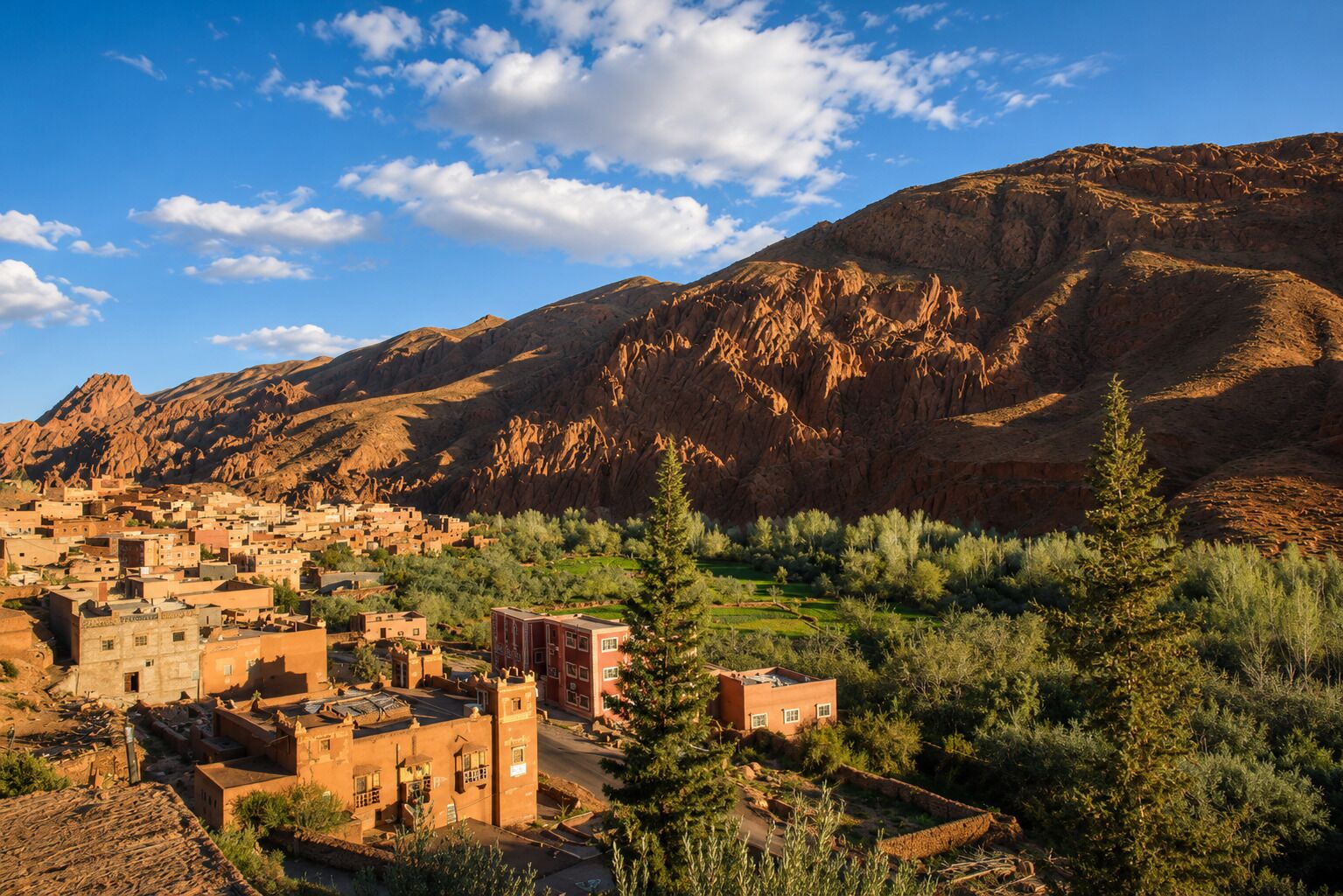 A mountainous landscape with a village featuring traditional architecture and terraced fields.
