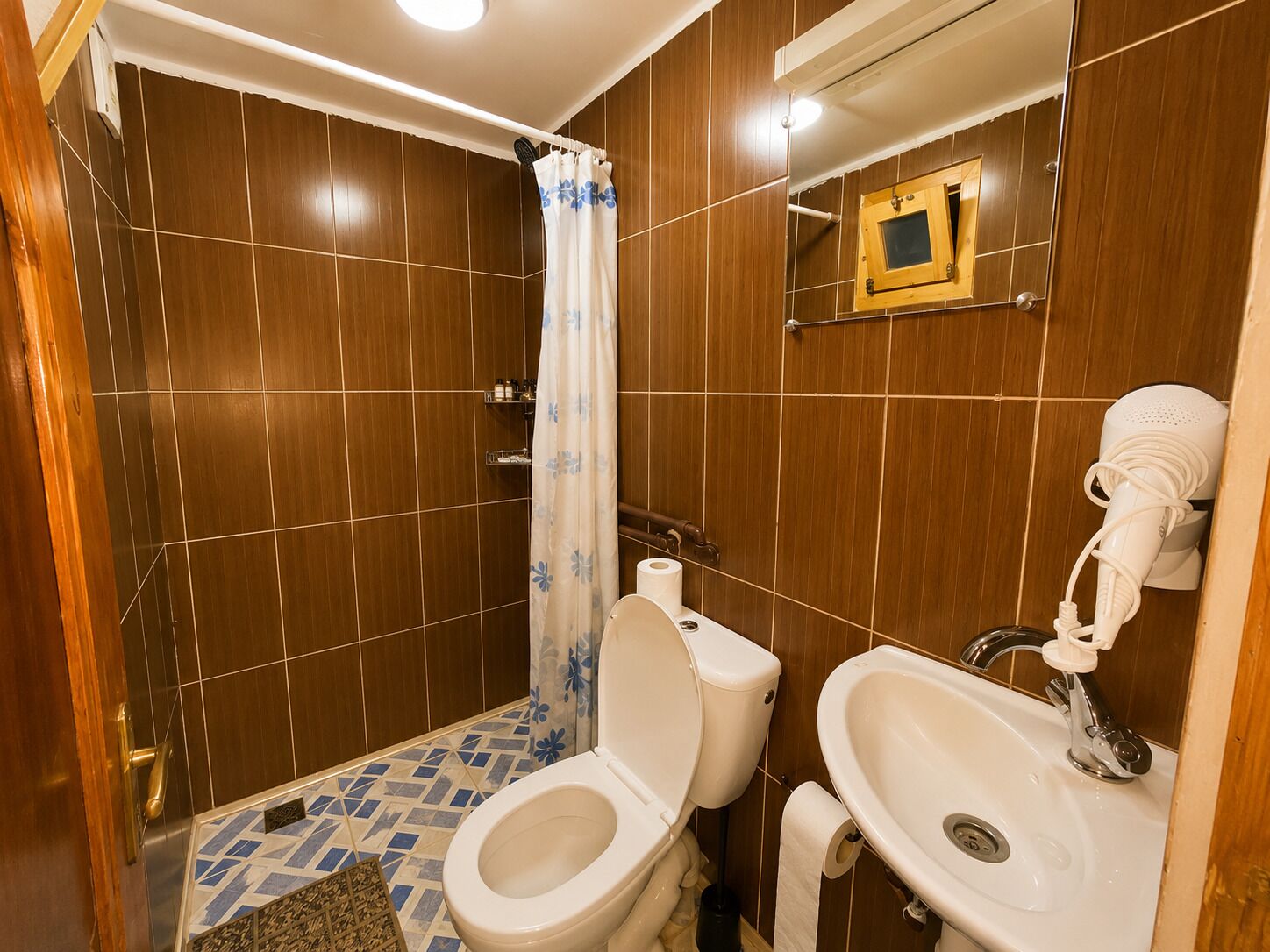 A bathroom with a shower, toilet, and sink.