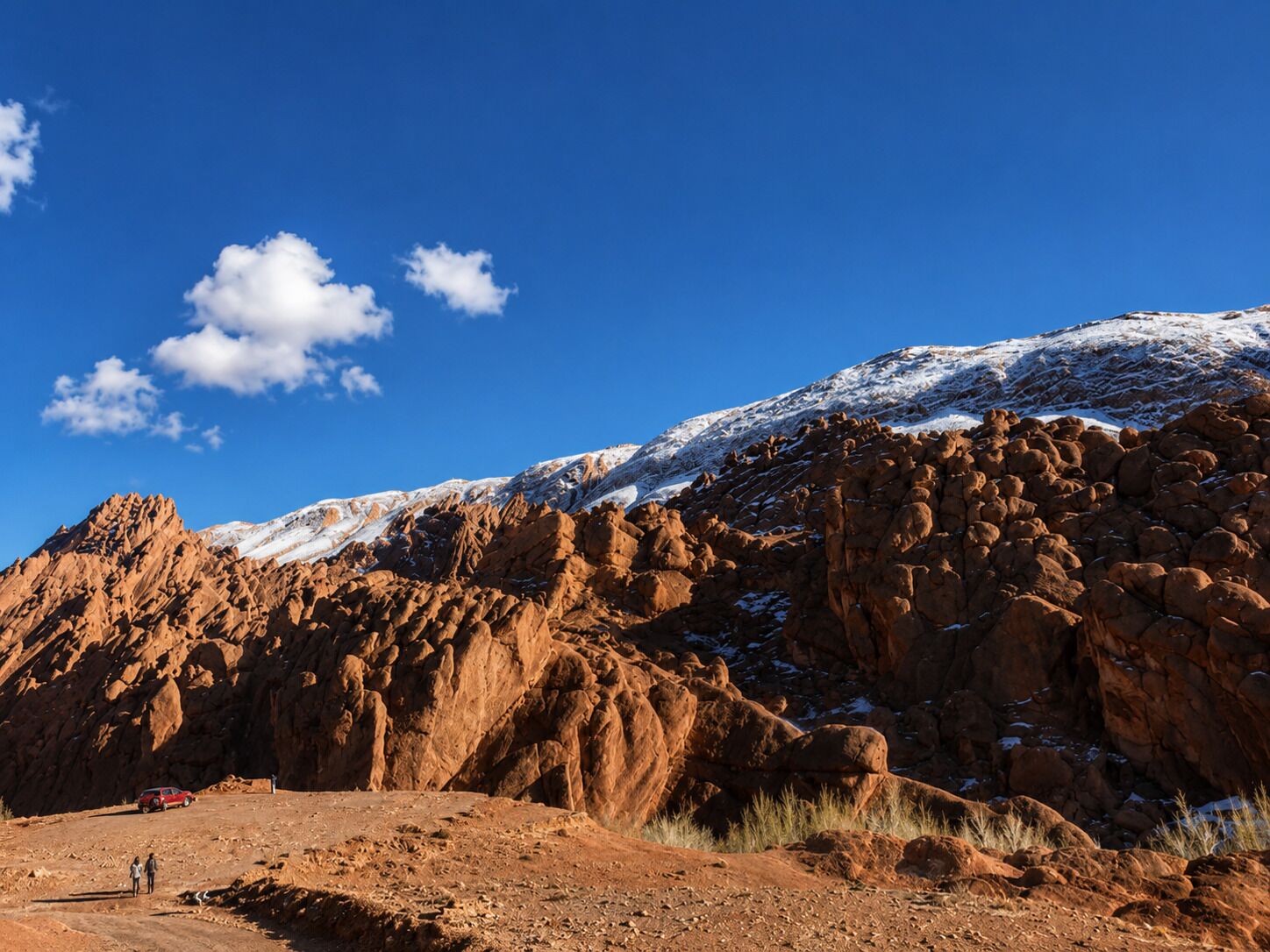 A rocky mountain landscape with a clear blue sky and a few clouds.