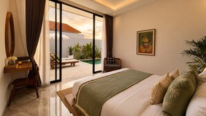A bedroom with a large bed, a desk, and a view of an outdoor swimming pool. - Villa Hibiscus II (Kabupaten Badung)