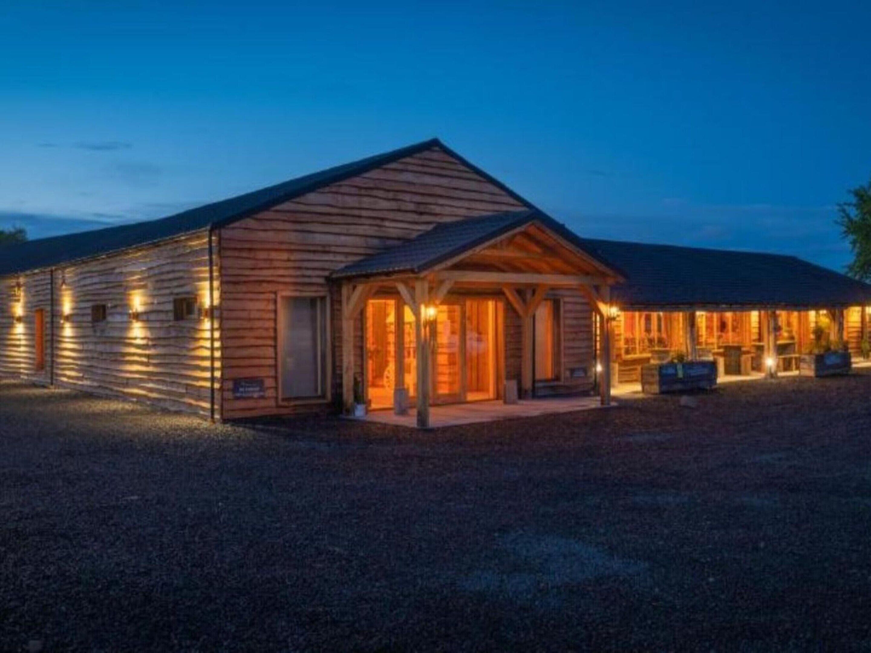 A wooden lodge with a covered porch and a gravel driveway.