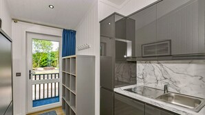 A modern kitchen with a marble countertop, stainless steel sink, and grey cabinets. - Lochside Perthshire Lodge for 4 (Perth)