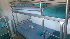 A bunk bed with a white fan and a small shelf unit. - Beautiful 2-Bedroom Townhouse, Frontignan, Secure Residential Complex, Beach Access 100 m Away (Frontignan)