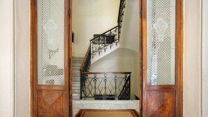 Una escalera de madera con una puerta de vidrio de cuadros que da a un rellano.