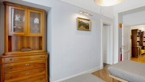 Un pasillo con un armario de madera, un cuadro enmarcado y una cama.