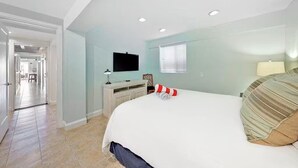 A hotel room with a bed, a desk, a television, and a window.
