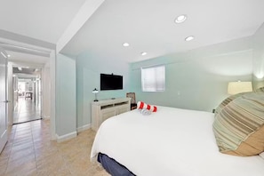 A hotel room with a bed, a desk, a television, and a window.
