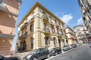 A multi-story building with a classical architectural style, featuring ornate balconies and a central entrance. - La Dimora Dei Reali – Yellow Suite with Wi-Fi and Air Conditioning (Naples)