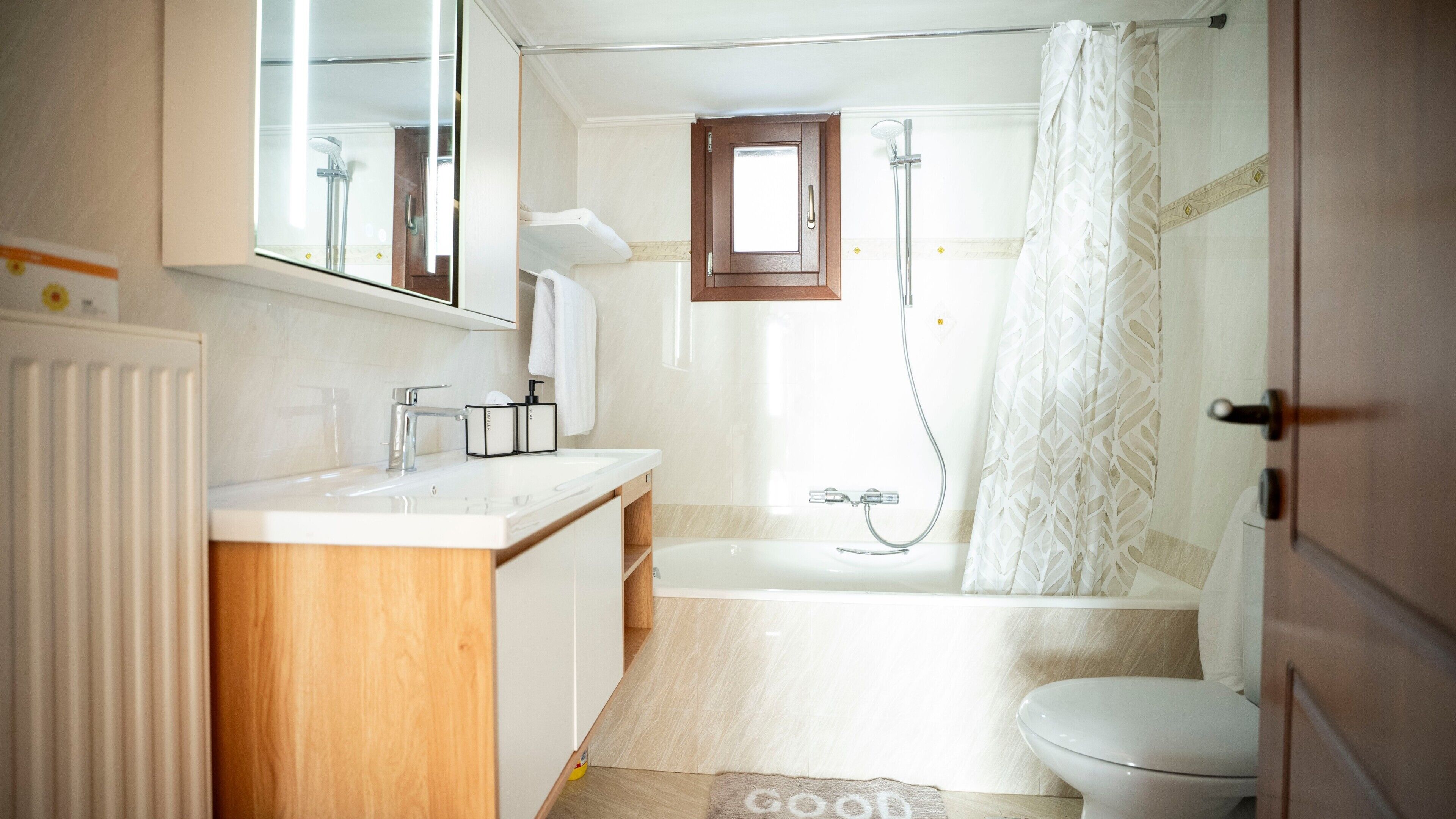 A bathroom with a bathtub, toilet, and sink.