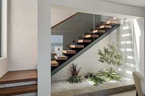 Eine moderne Treppe mit Holzboden und Glasgeländern, die zu einer oberen Ebene führt.