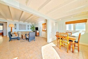 A spacious living area with a dining table and chairs, a sofa, and a coffee table.