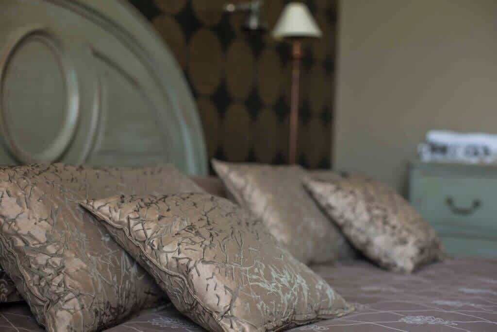 A bed with patterned pillows and a headboard.