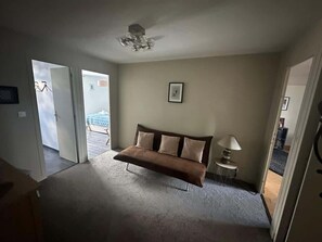 Une pièce avec un canapé, une lampe et un ventilateur de plafond.