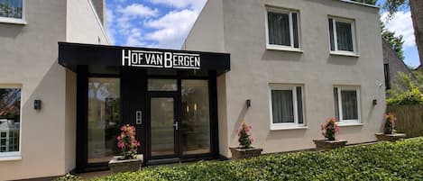 A building with a sign reading 'Hof van Bergen' and a modern architectural style.