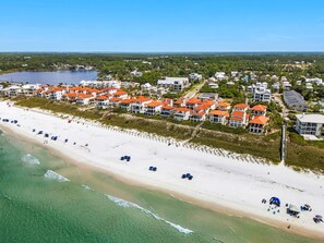 Ein Küstenresort mit Strandvillen, einem Sandstrand und klarem, blauem Wasser.