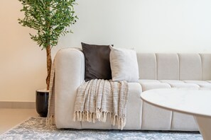 Un salon moderne avec un canapé, une table basse et une plante en pot.