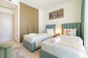 Ein Hotelzimmer mit zwei Betten, einem Schrank, einem Gemälde und einer Uhr.