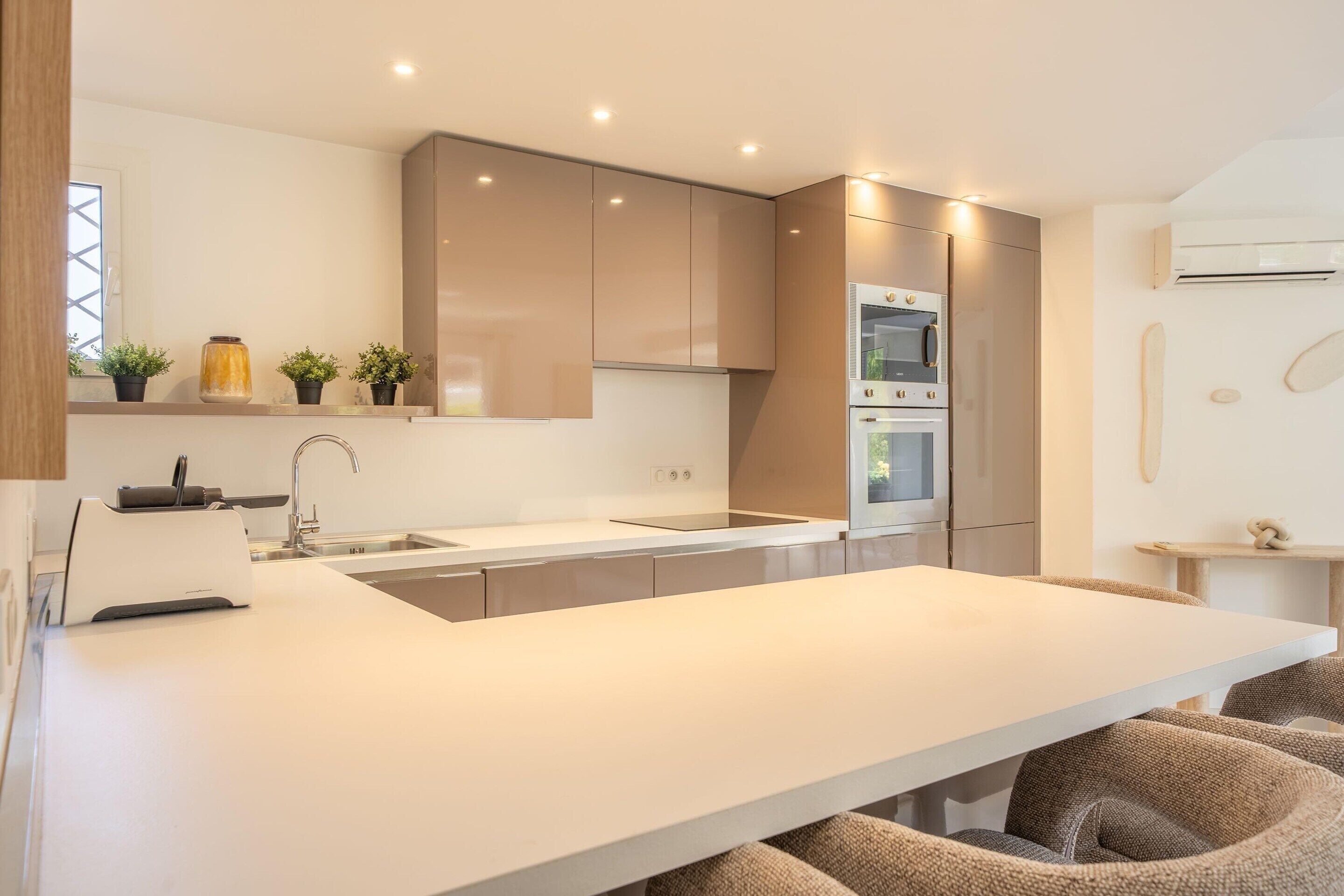 Una cocina moderna con una isla central, electrodomésticos integrados y un diseño minimalista.