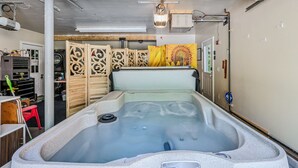 A spa room with a hot tub, wooden dividers, and a ceiling fan. - Pet-Friendly Above Garage Suite - Shared Hot Tub (Clarendon)