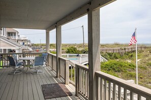 A wooden deck with outdoor seating and a view of the beach and ocean. - Blue Horizon - Oceanfront Home (Atlantic Beach)
