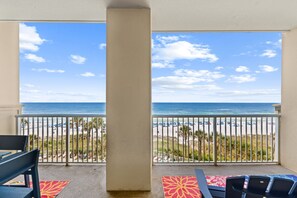 Un balcon avec vue sur la plage et l’océan.