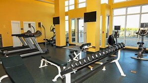 A gym with treadmills, a bench press, and weight machines. - Ocean Breeze! 5th Floor 2BR Gulf-Front Condo Sleeps 6 (Panama City Beach)
