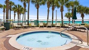 A swimming pool with palm trees and beach chairs. - Ocean Breeze! 5th Floor 2BR Gulf-Front Condo Sleeps 6 (Panama City Beach)