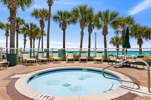 A swimming pool with palm trees and beach chairs. - Ocean Breeze! 5th Floor 2BR Gulf-Front Condo Sleeps 6 (Panama City Beach)