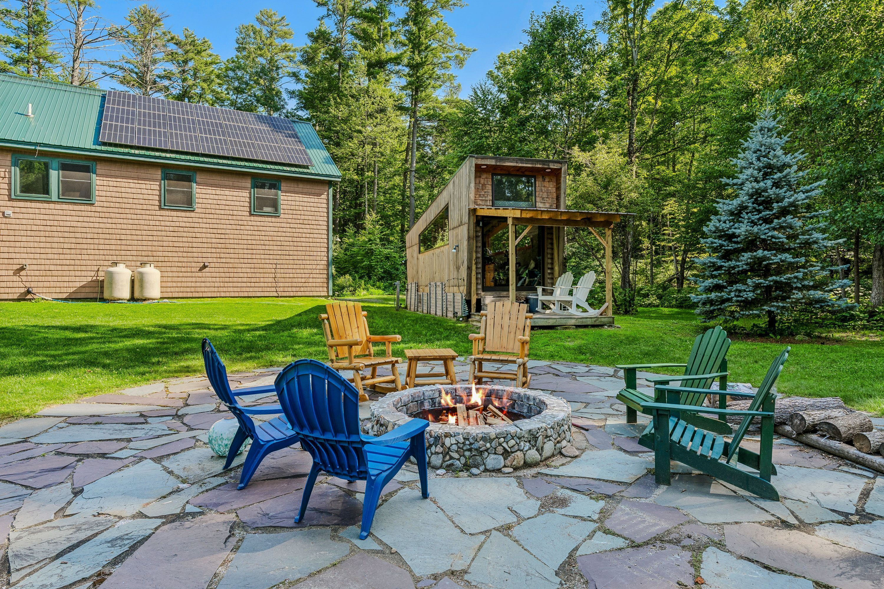 Une cabane avec un foyer et des sièges extérieurs.