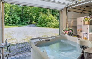 Ein Whirlpool mit Blick auf einen Kiesweg, der zu einem Wald führt.