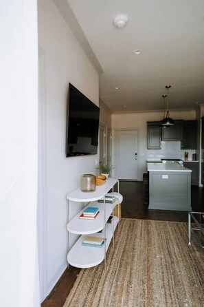 A modern kitchen with grey cabinets, a white countertop, and a hanging pendant light. - Lovely 1BR · Williams-Brice & Fort Jackson (Columbia)