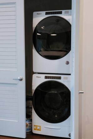 A laundry room with two stacked Whirlpool washers.